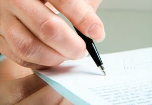 Photo of ballpoint in the female hand over a contract